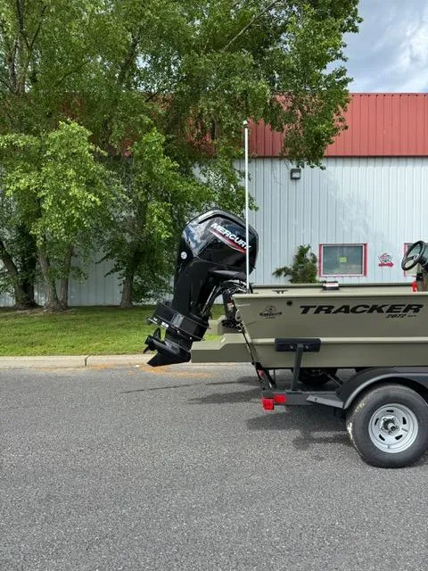 Slide: The Image of 2025 Tracker Grizzly 2072 CC boat on trailer, parked outdoors near a building. - 2