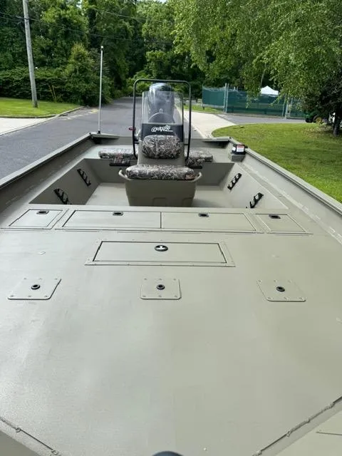 Slide: The Image of 2025 Tracker Grizzly 2072 CC boat with spacious deck and center console, parked outdoors. - 8