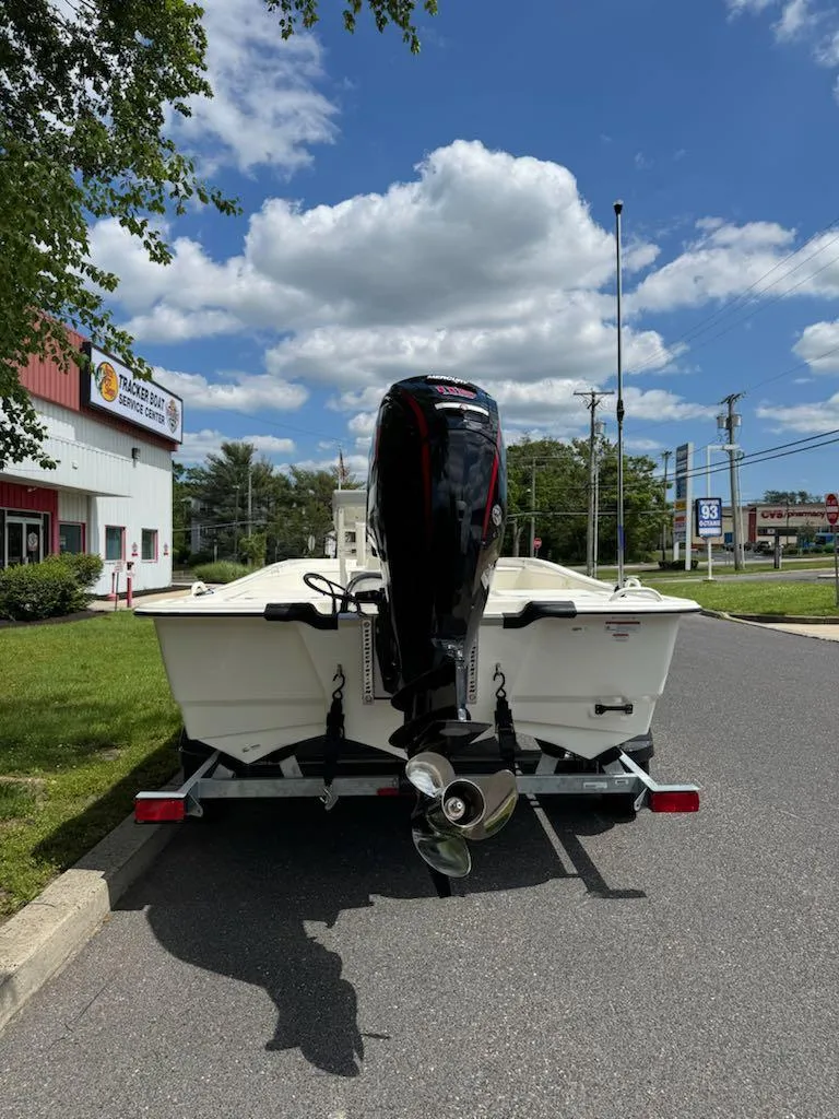 Slide: The Image of 2025 Mako Pro Skiff 19 CC boat on trailer, parked outdoors under a cloudy sky. - 5