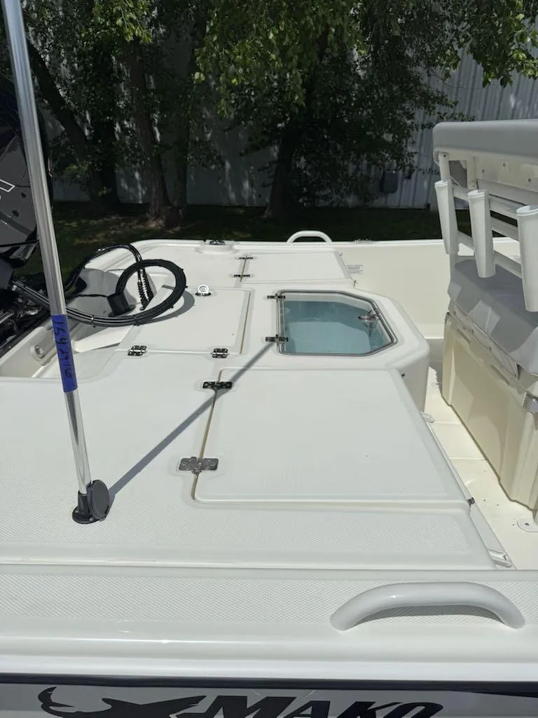 Slide: The Image of 2025 Mako Pro Skiff 19 CC boat deck with steering wheel and storage compartments. - 9