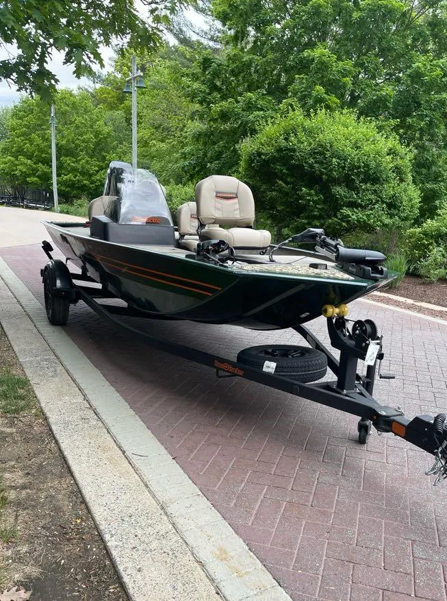 Slide: The Image of 2025 Tracker Bass Tracker Classic Limited boat on trailer, parked on a brick path. - 2