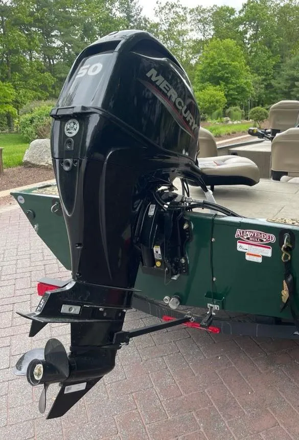 Slide: The Image of 2025 Tracker Bass Tracker Classic Limited with Mercury outboard motor in a scenic outdoor setting. - 5