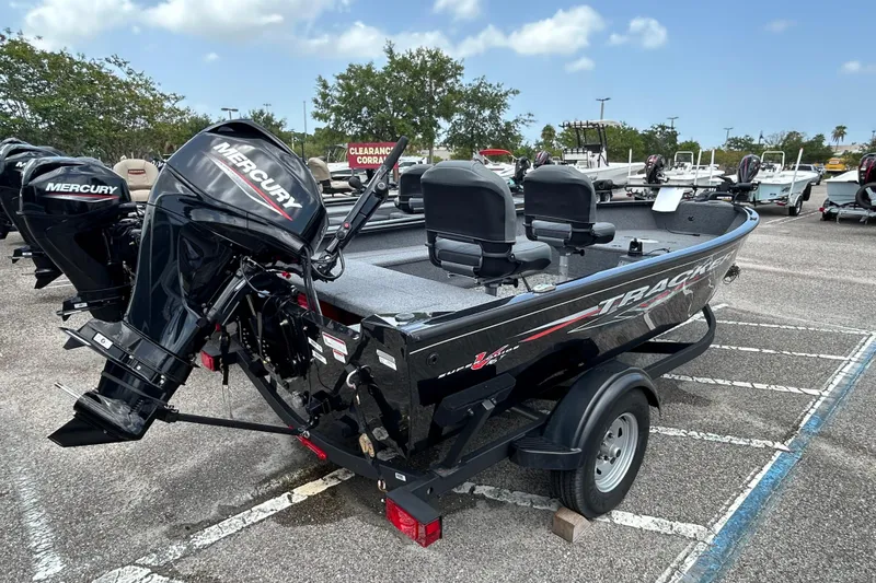 Slide: The Image of 2025 Tracker Super Guide V-16 T boat with Mercury engine in parking lot. - 2
