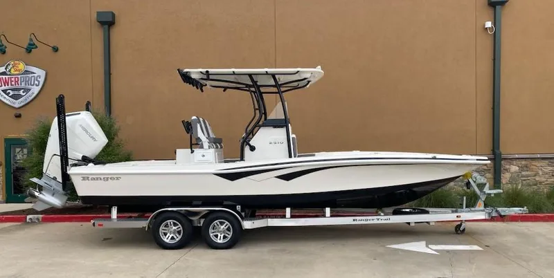 Slide: The Image of 2025 Ranger 2510 Bay boat on trailer, side view, parked outdoors. - 2