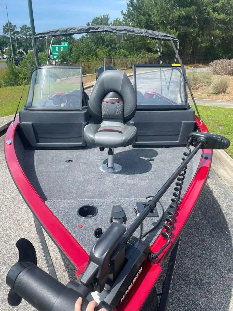 Slide: The Image of 2025 Tracker Pro Guide V-175 Combo boat with red exterior and fishing seat. - 2