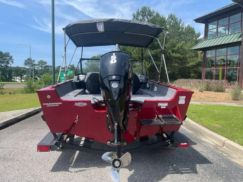 Slide: The Image of 2025 Tracker Pro Guide V-175 Combo boat, red, parked outdoors with outboard motor. - 3