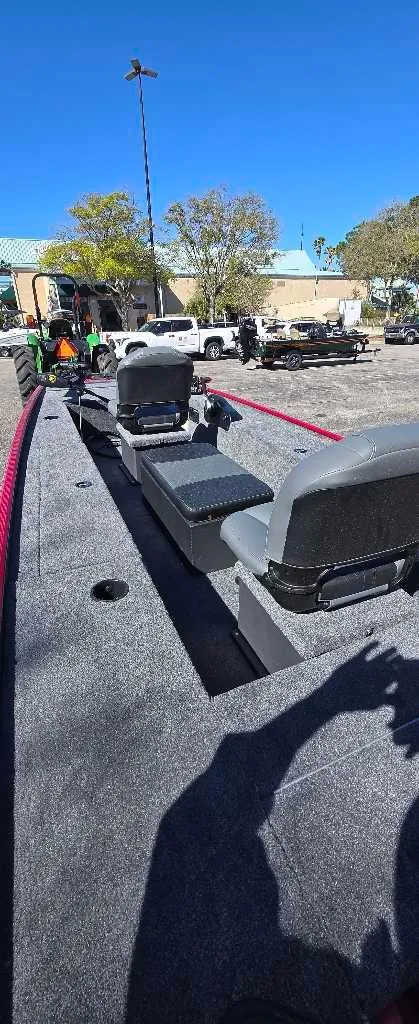 Slide: The Image of 2025 Tracker Panfish 17 boat with seating, parked outdoors under clear blue sky. - 3