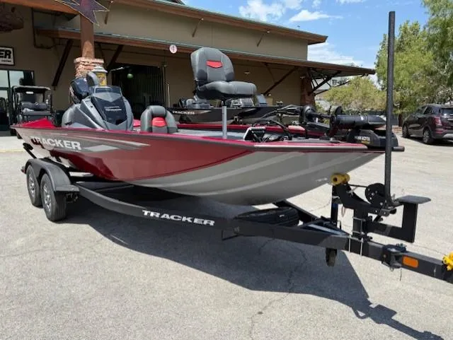 Slide: The Image of 2025 Tracker Pro Team 195 Tournament Edition boat on trailer, parked outdoors. - 2