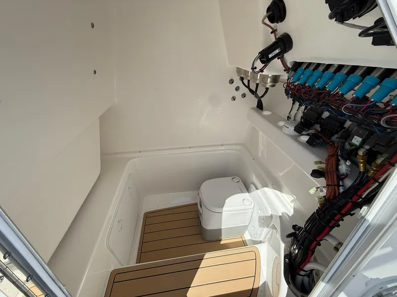 Slide: The Image of Interior of 2025 Cape Horn 24 XS boat, featuring a compact toilet and electrical components. - 25