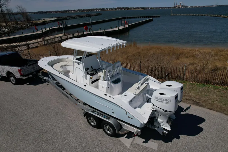 Slide: The Image of 2025 Cape Horn 24 XS boat on trailer by waterfront, featuring dual Suzuki engines. - 3