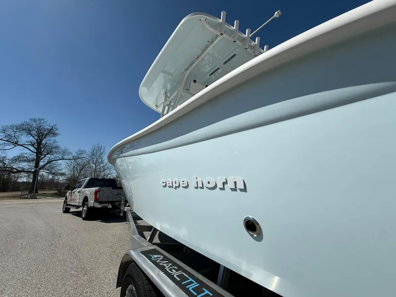 Slide: The Image of 2025 Cape Horn 24 XS boat on trailer, parked near a truck under clear blue sky. - 33