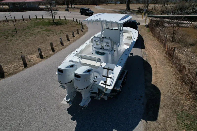 Slide: The Image of 2025 Cape Horn 24 XS boat with dual engines on a trailer, parked on a road. - 6