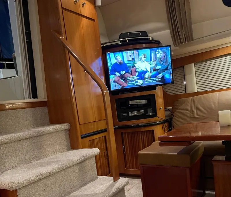 Slide: The Image of Interior of 2002 Carver 396 Motor Yacht with TV, stairs, and seating area. - 12