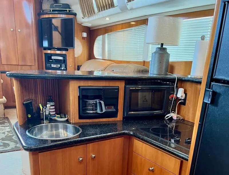 Slide: The Image of Interior of 2002 Carver 396 Motor Yacht with kitchenette, sink, and appliances. - 15