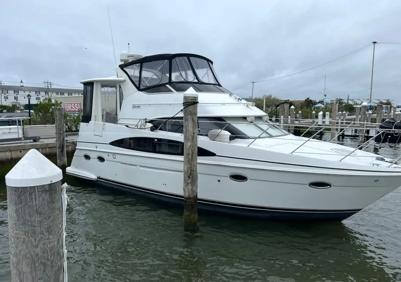 Slide: The Image of 2002 Carver 396 Motor Yacht docked in a marina, overcast sky. - 3