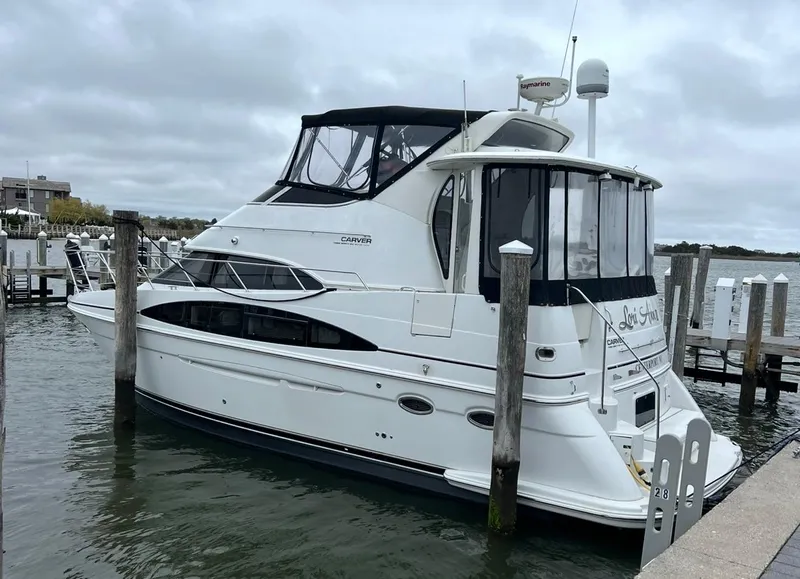 Slide: The Image of 2002 Carver 396 Motor Yacht docked at a marina under cloudy skies. - 4