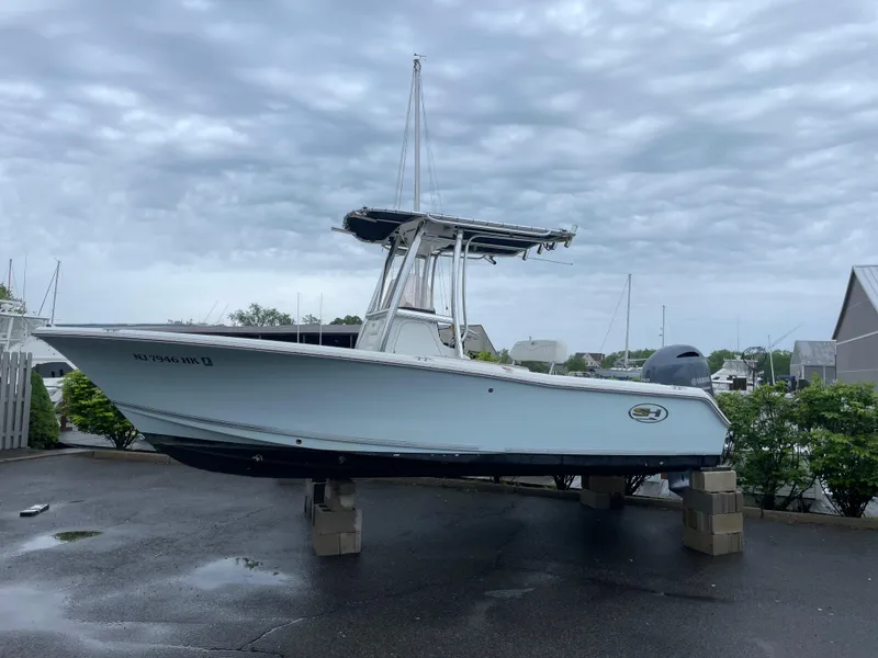 Slide: The Image of 2017 Sea Hunt 21 CC boat on blocks, overcast sky, marina background. - 1