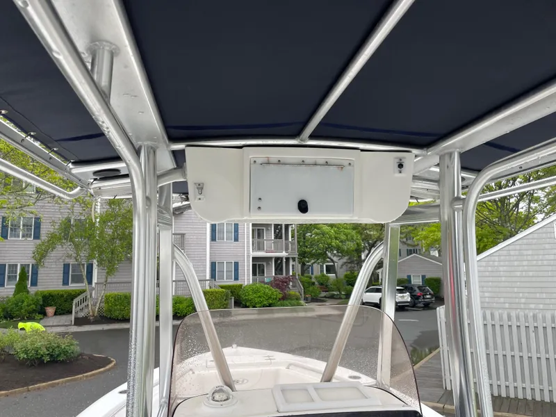 Slide: The Image of 2017 Sea Hunt 21 CC boat with T-top and console, parked in residential area. - 12