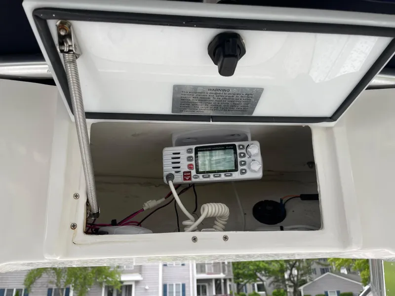 Slide: The Image of 2017 Sea Hunt 21 CC boat console with radio equipment in storage compartment. - 13