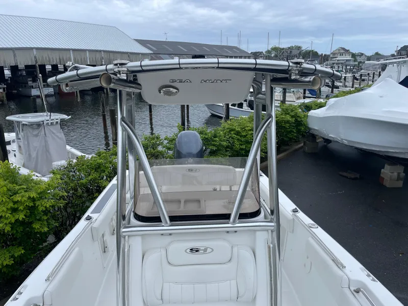 Slide: The Image of 2017 Sea Hunt 21 CC boat docked at marina, featuring center console and T-top. - 17
