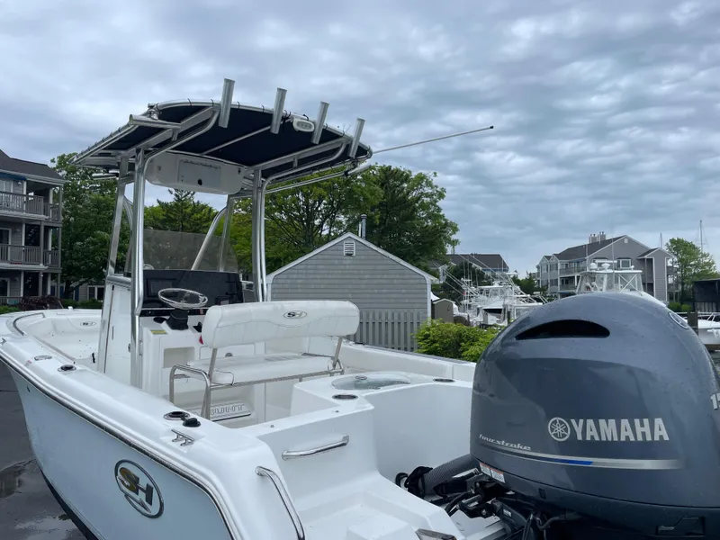 Slide: The Image of 2017 Sea Hunt 21 CC boat with Yamaha engine, docked under cloudy skies. - 3