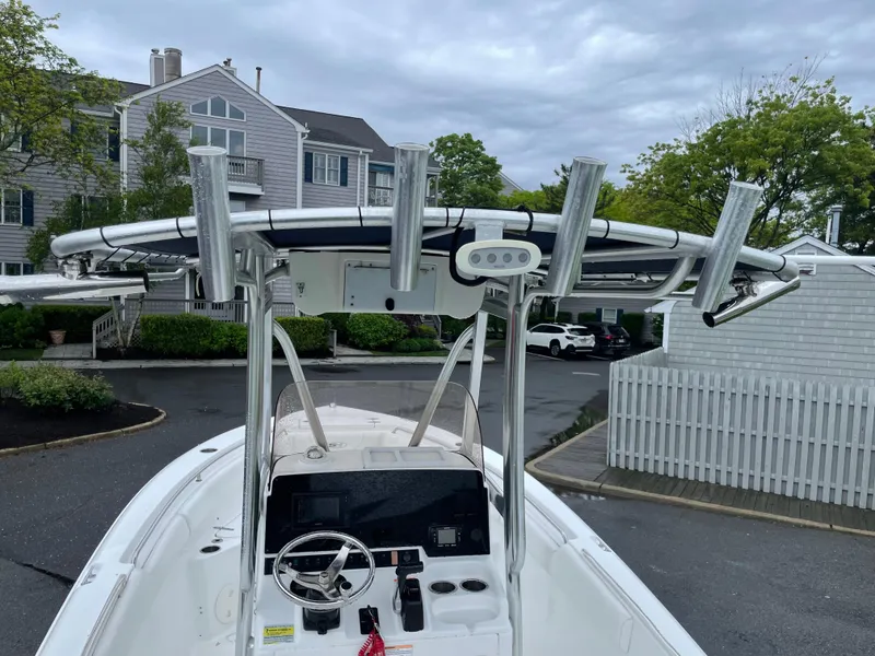 Slide: The Image of 2017 Sea Hunt 21 CC boat with T-top and rod holders, parked in residential area. - 9