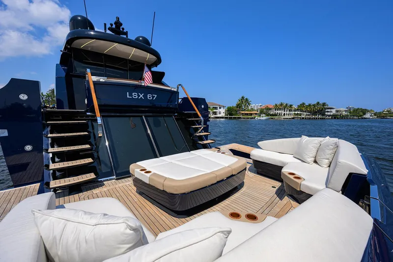 Slide: The Image of 2023 Lazzara LSX 67 yacht with luxurious deck seating and scenic waterfront view. - 10