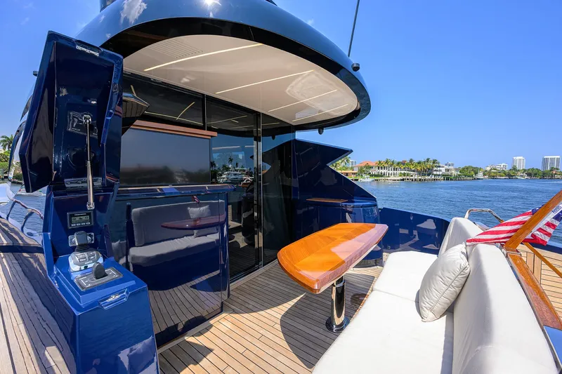 Slide: The Image of 2023 Lazzara LSX 67 yacht deck with seating and table, overlooking serene waterfront. - 5