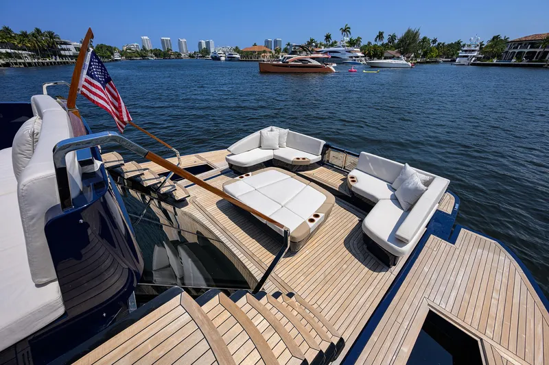 Slide: The Image of Luxurious 2023 Lazzara LSX 67 yacht with elegant deck seating on a sunny waterfront. - 7