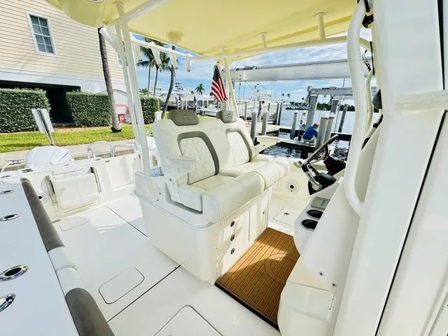 Slide: The Image of 2020 World Cat 32 boat interior with plush seating and helm, docked at marina. - 17