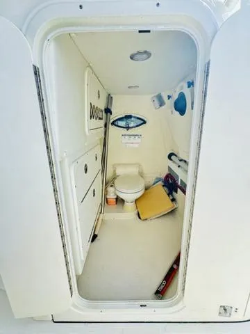 Slide: The Image of Interior of a 2020 World Cat 32 boat bathroom, featuring a compact toilet and storage. - 22
