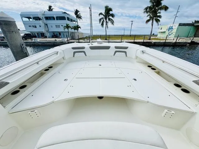 Slide: The Image of 2020 World Cat 32 boat deck with seating, docked near palm trees and waterfront buildings. - 29