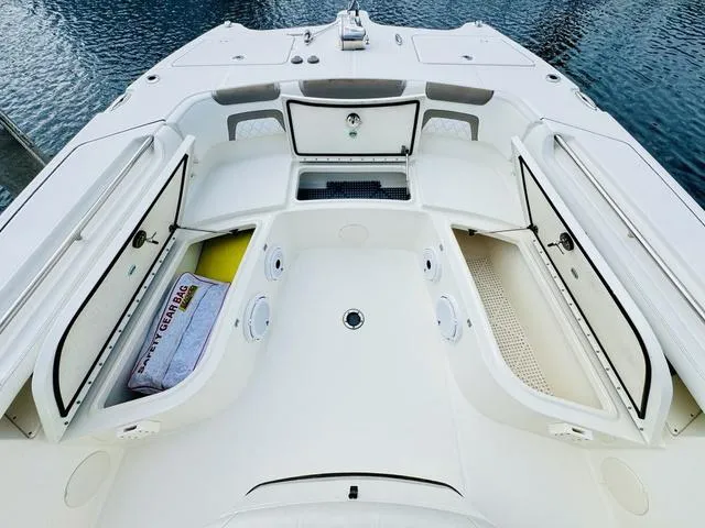 Slide: The Image of 2020 World Cat 32 boat deck with open storage compartments, docked on calm water. - 32