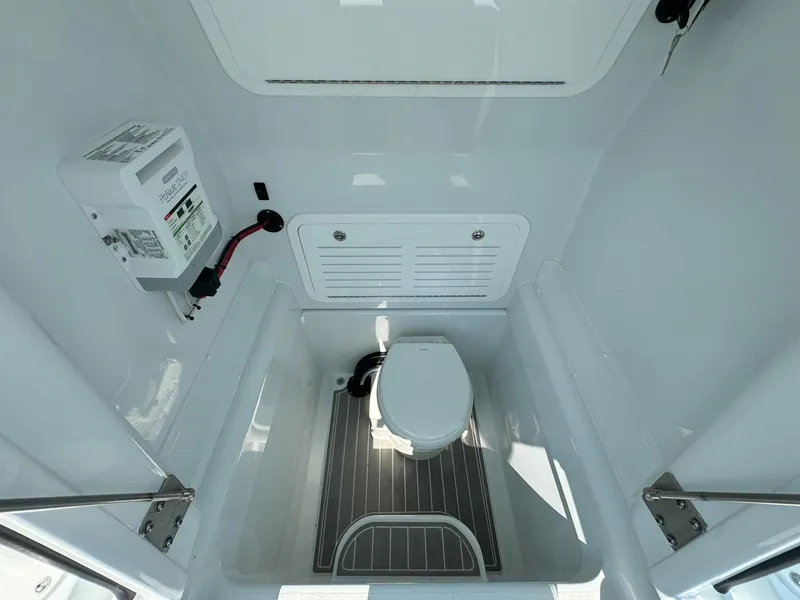 Slide: The Image of 2025 Yellowfin 34 Offshore boat interior with compact marine toilet and control panel. - 37