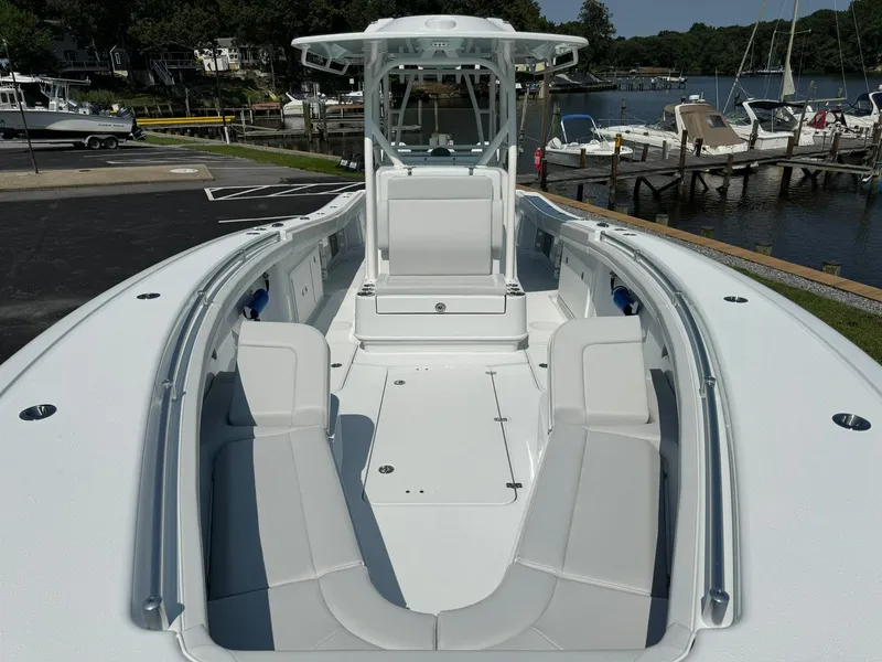 Slide: The Image of 2025 Yellowfin 34 Offshore boat with spacious seating and sleek design at a marina. - 11