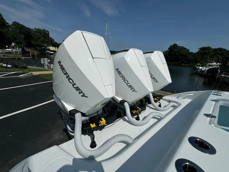 Slide: The Image of Triple Mercury outboard engines on 2025 Yellowfin 34 Offshore boat, docked by a serene lake. - 25