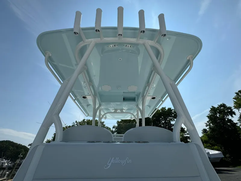 Slide: The Image of 2025 Yellowfin 34 Offshore boat, view of T-top and rod holders under clear sky. - 28