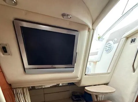 Slide: The Image of Interior of 2005 Sea Ray 320 Sundancer with mounted TV and seating area. - 11