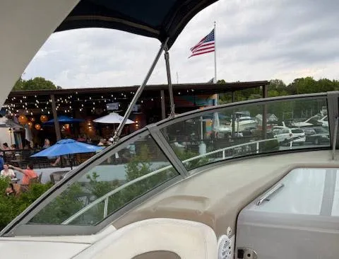 Slide: The Image of 2005 Sea Ray 320 Sundancer boat near marina with American flag and outdoor dining area. - 14