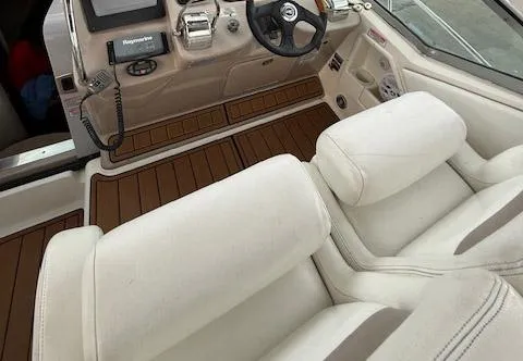 Slide: The Image of 2005 Sea Ray 320 Sundancer helm with white seating and wood-accented dashboard. - 16