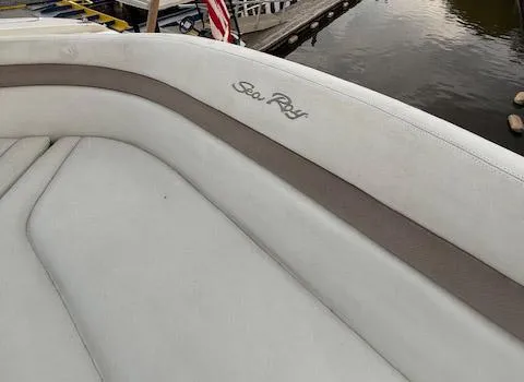 Slide: The Image of 2005 Sea Ray 320 Sundancer boat interior with logo, docked by calm water. - 19