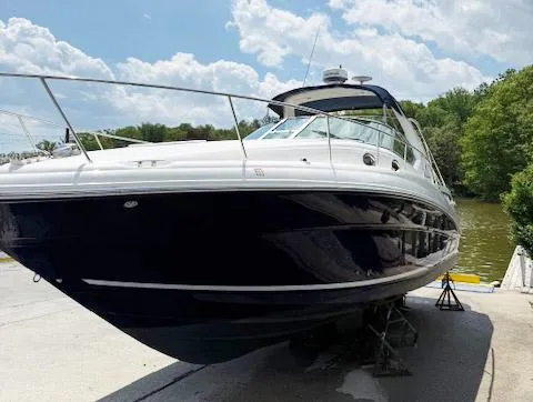 Slide: The Image of 2005 Sea Ray 320 Sundancer boat on dry dock, sunny day, lush greenery background. - 3