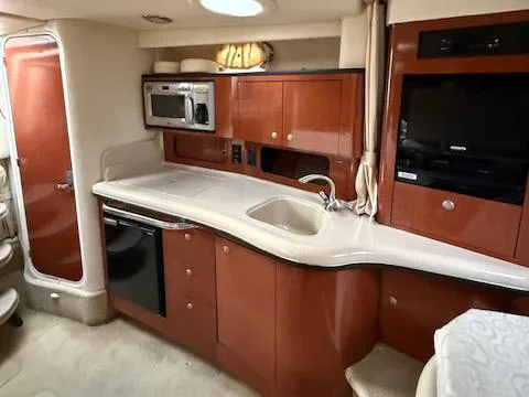 Slide: The Image of Interior of 2005 Sea Ray 320 Sundancer yacht with kitchenette and modern amenities. - 5