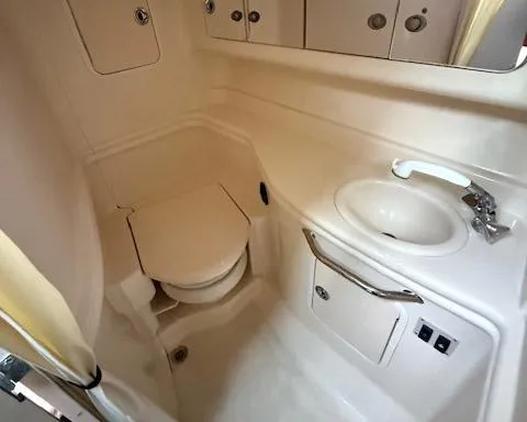 Slide: The Image of 2005 Sea Ray 320 Sundancer bathroom with toilet, sink, and storage cabinets. - 6
