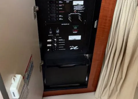 Slide: The Image of Electrical panel inside a 2005 Sea Ray 320 Sundancer boat, featuring switches and controls. - 8