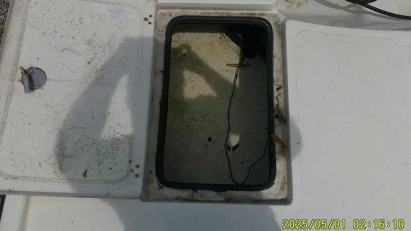 Slide: The Image of Open hatch on 2023 Mako 18 LTS boat with visible water and shadow. - 11