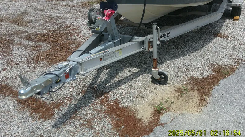 Slide: The Image of 2023 Mako 18 LTS boat trailer parked on gravel surface. - 12