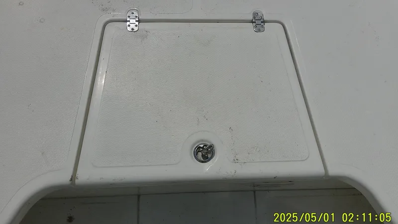 Slide: The Image of 2023 Mako 18 LTS boat hatch with hinges and latch, dated May 1, 2025. - 2