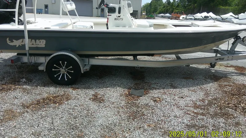 Slide: The Image of 2023 Mako 18 LTS boat on trailer, parked outdoors. - 22