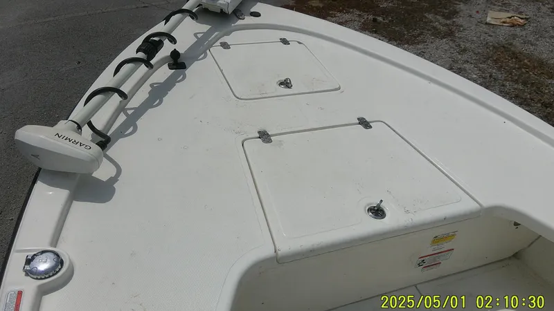 Slide: The Image of 2023 Mako 18 LTS boat deck with storage compartments and Garmin equipment. - 28